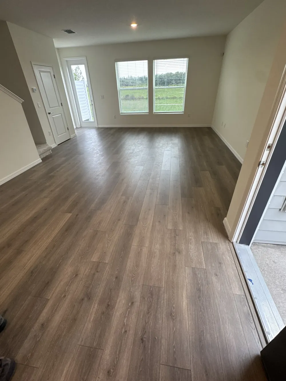Light wide-plank flooring installed through an open living area